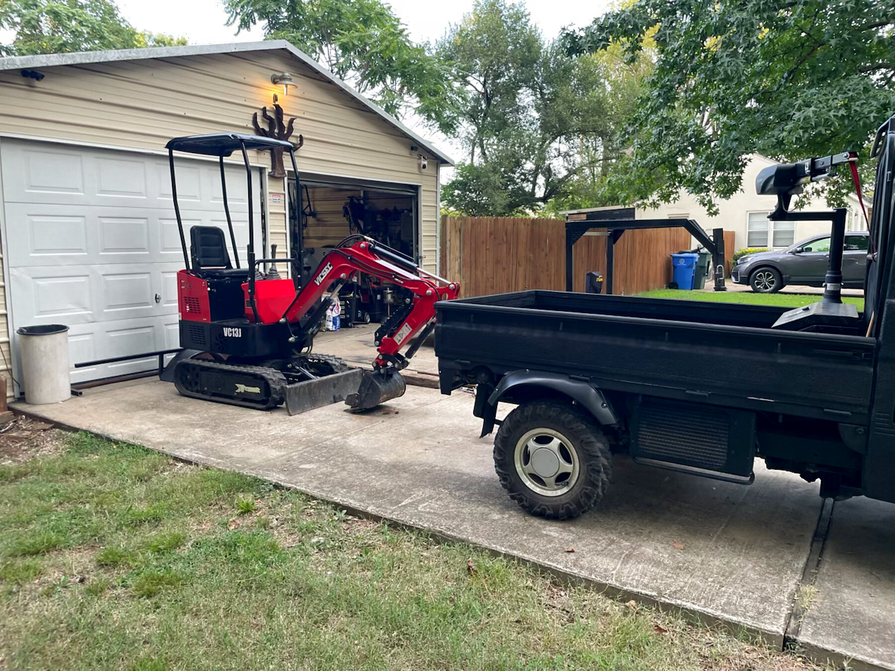 Little Diggers mini excavator loaded beside a compact dump truck